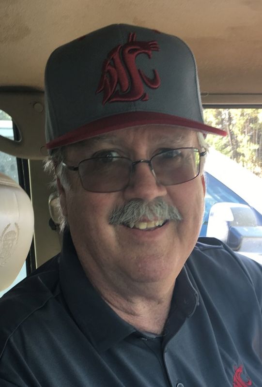 an obituary photo of Bruce D. Lyle wearing a WSU Cougars ball cap