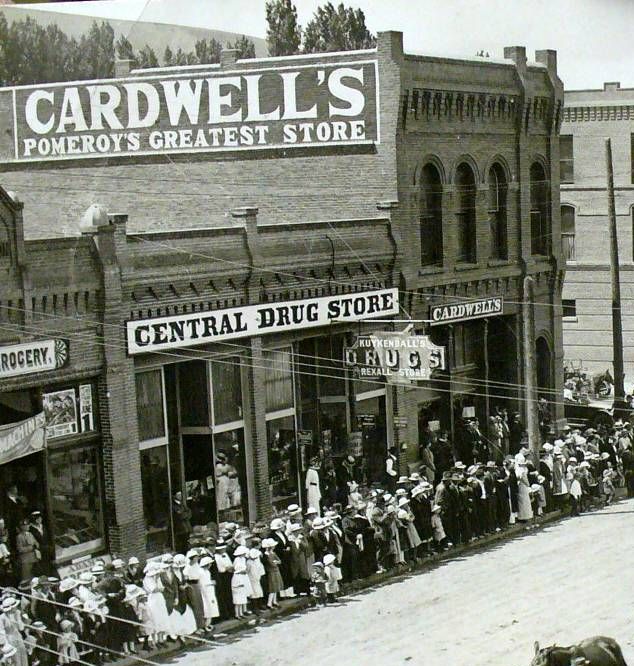 photo of parade passing in front of Central Drug Store, Pomeroy WA, undated.